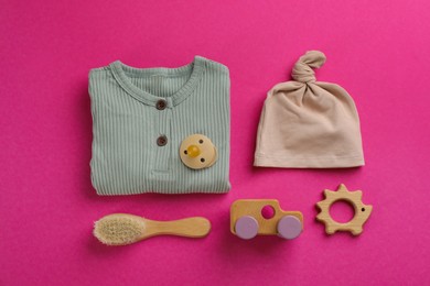 Flat lay composition with baby clothes and accessories on pink background