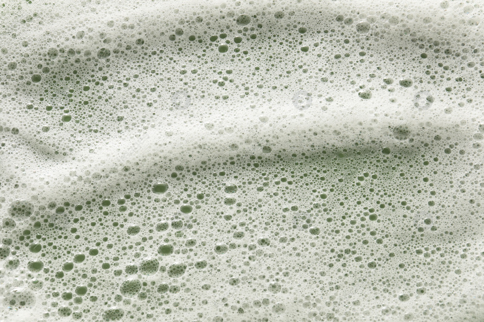 Photo of White washing foam on olive background, top view