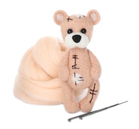 Felted bear, wool and needles isolated on white
