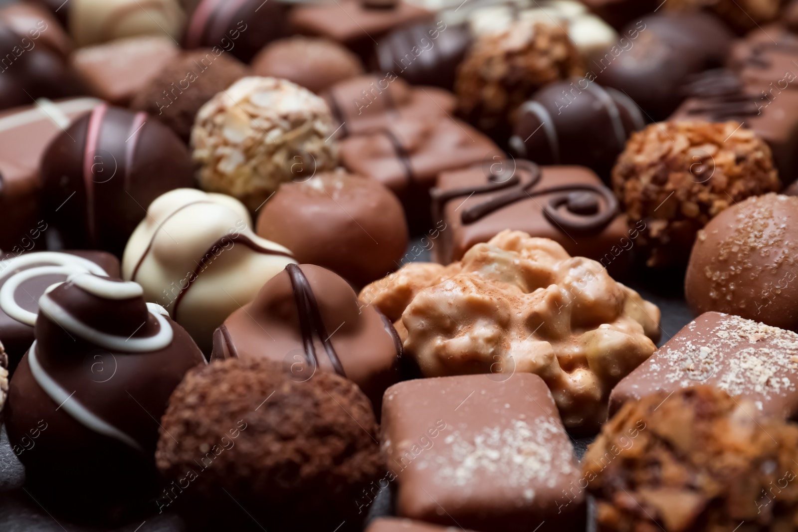 Photo of Different delicious chocolate candies as background, closeup