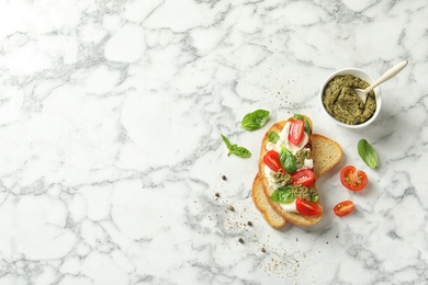 Toasted bread with tasty cream cheese and tomatoes on marble table, flat lay. Space for text