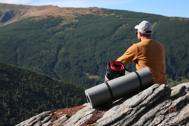 Photo of Tourist with sleeping bag and mat on mountain peak