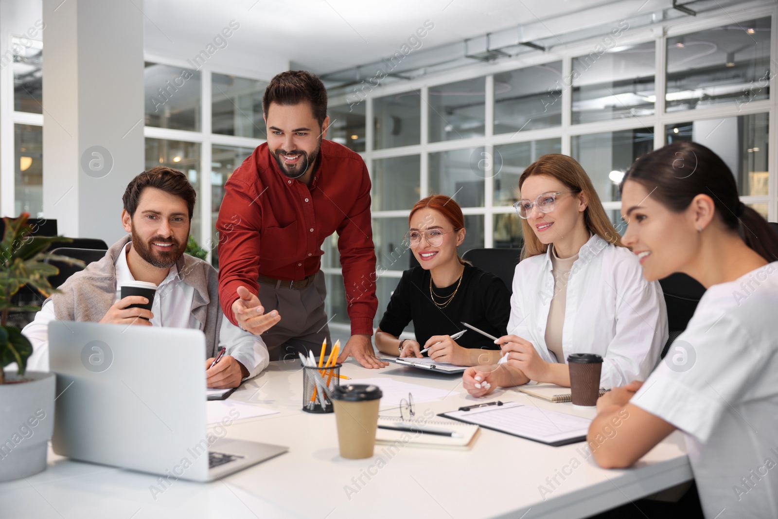 Photo of Team of employees working together in office