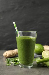 Green juice and fresh ingredients on grey table