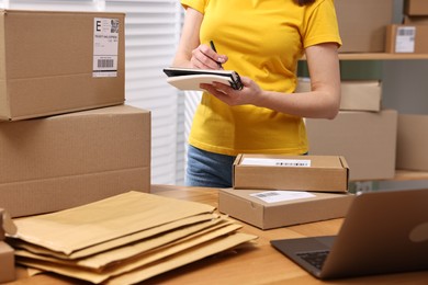 Parcel packing. Post office worker writing notes indoors, closeup