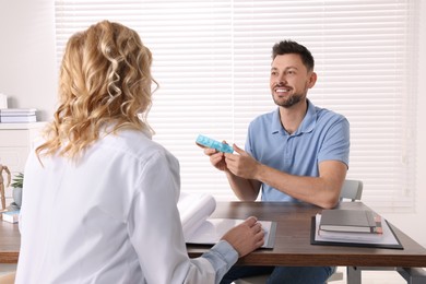 Photo of Doctor consulting patient at table in clinic