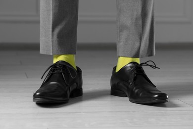 Photo of Man wearing stylish shoes and yellow socks indoors, closeup