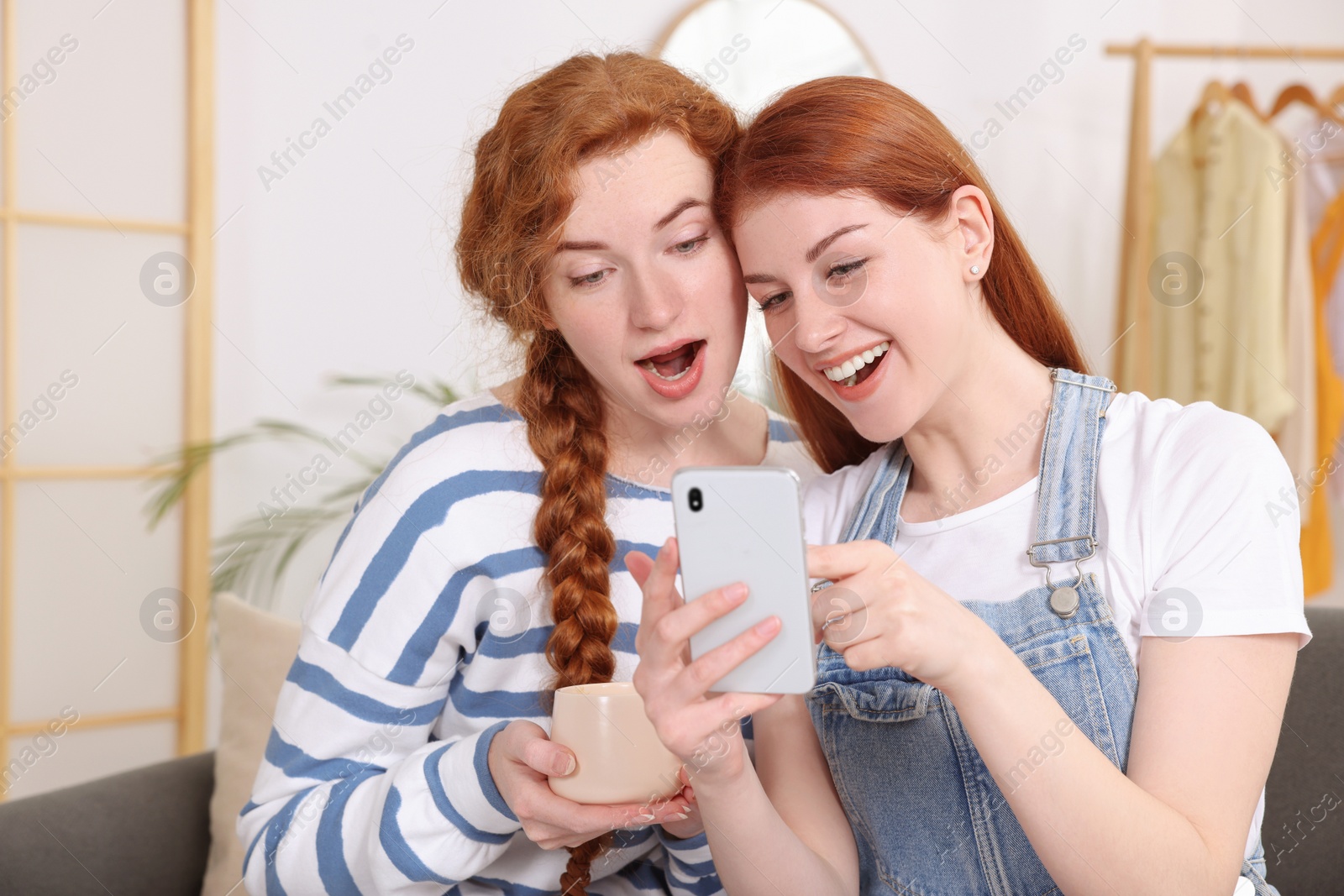 Photo of Beautiful young sisters spending time together at home