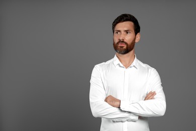 Portrait of handsome bearded man on grey background, space for text