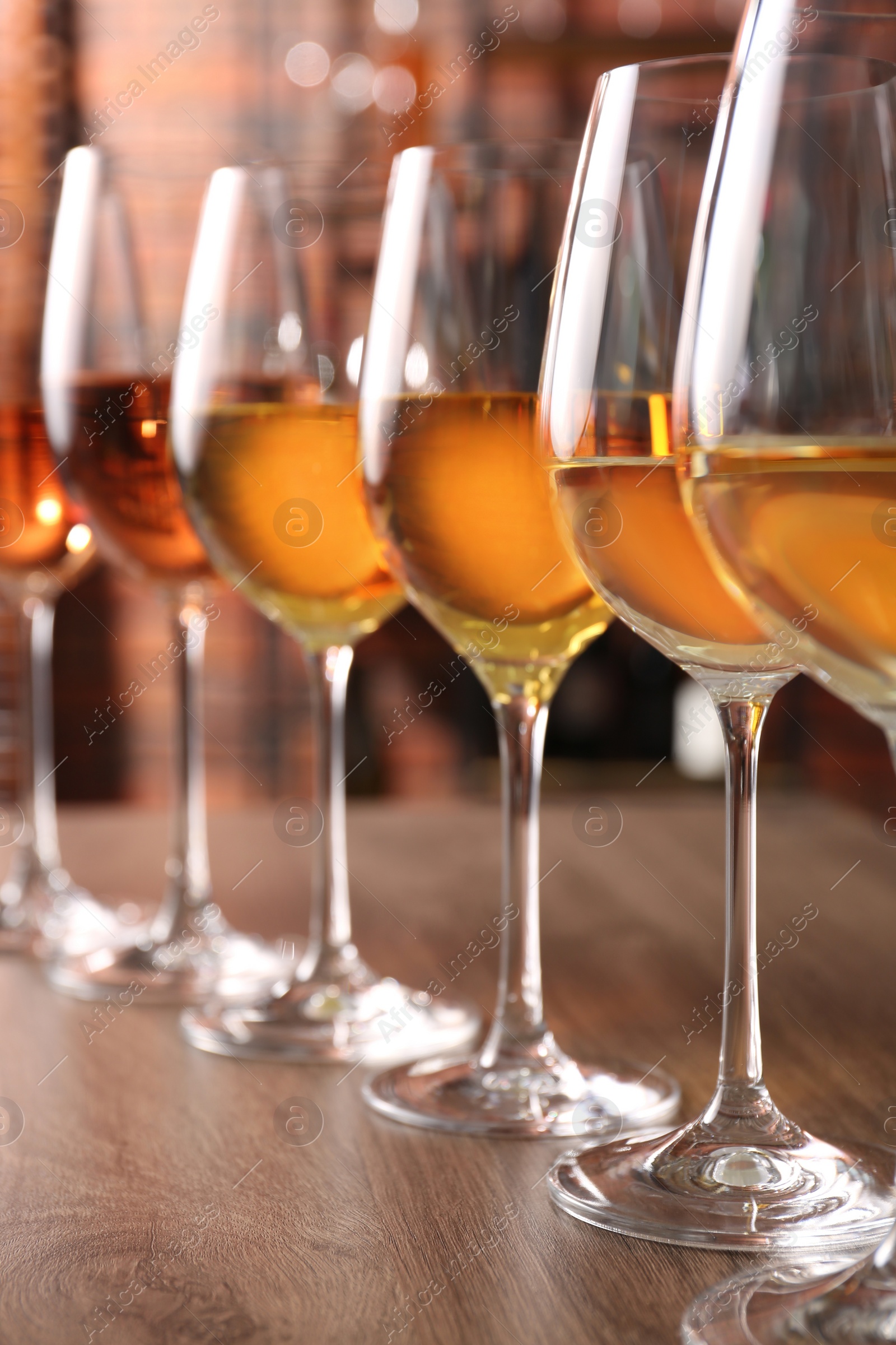 Photo of Different tasty wines in glasses on wooden table