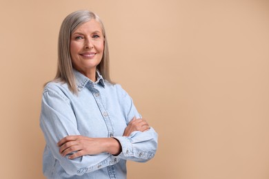 Photo of Portrait of beautiful middle aged woman on beige background, space for text