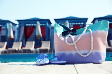 Photo of Beach accessories near swimming pool on sunny day. Space for text