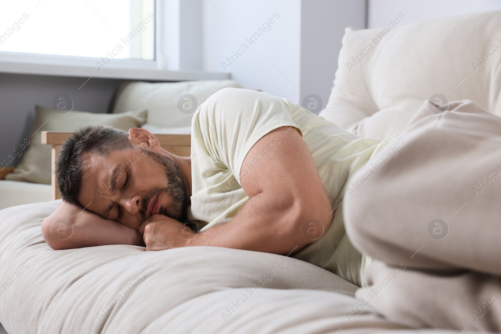 Photo of Tired man sleeping on sofa at home