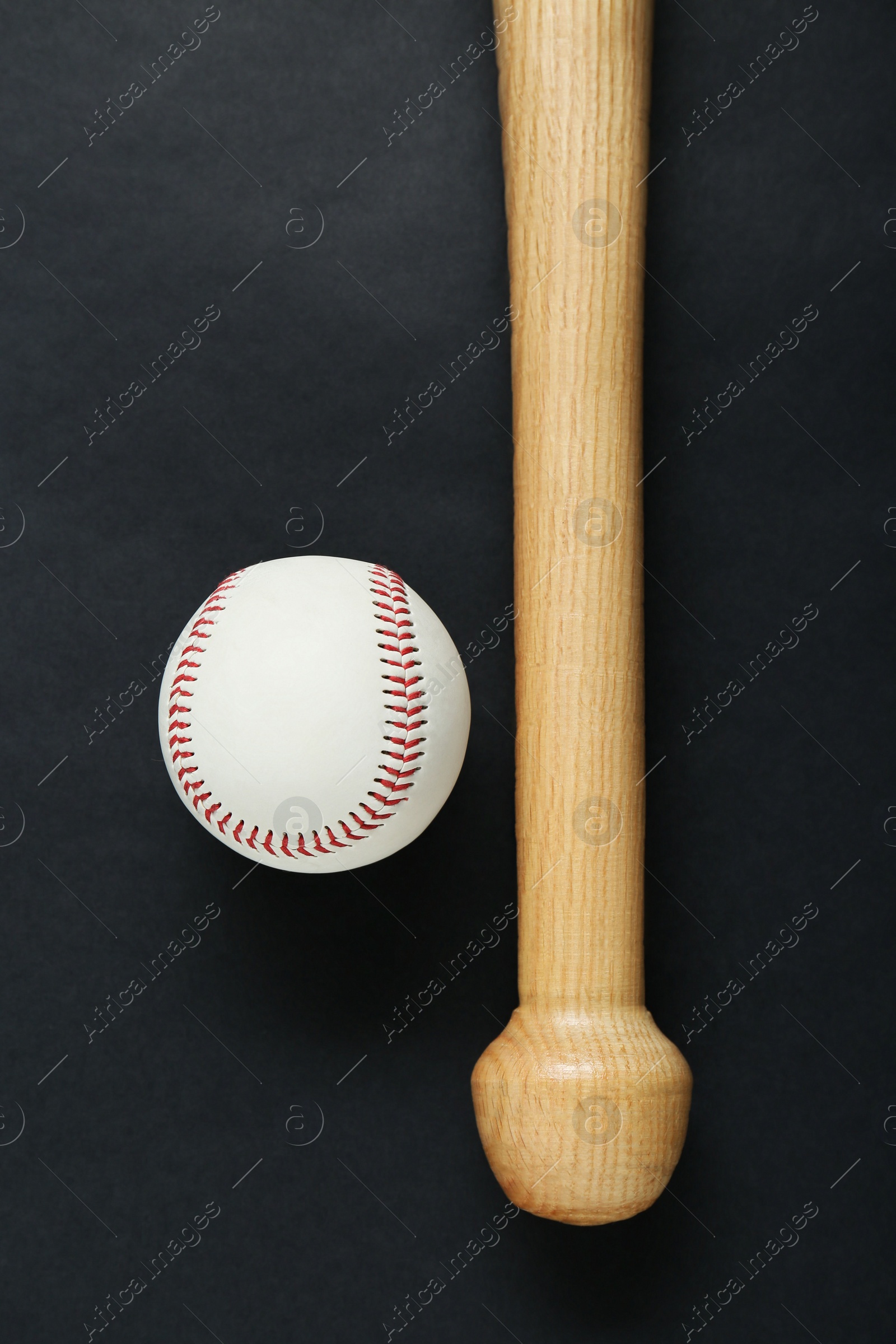 Photo of Wooden baseball bat and ball on black background, flat lay. Sports equipment