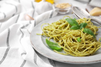 Photo of Delicious pasta with pesto sauce and basil on table, closeup. Space for text