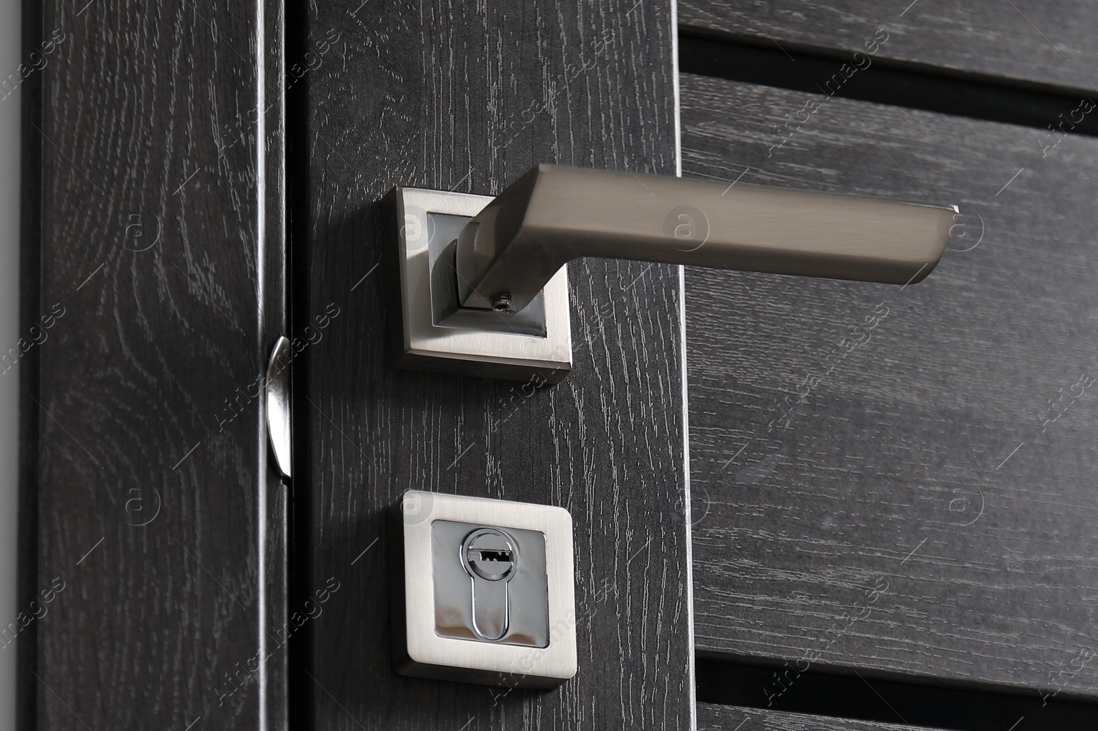 Photo of Dark wooden door with metal handle, closeup