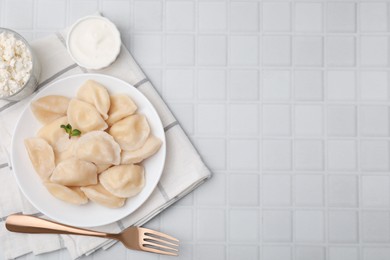 Photo of Delicious dumplings (varenyky) with cottage cheese served on white table, flat lay. Space for text