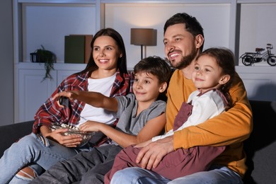 Happy family watching TV at home in evening