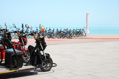 Photo of Parking with bicycles on embankment near sea, space for text