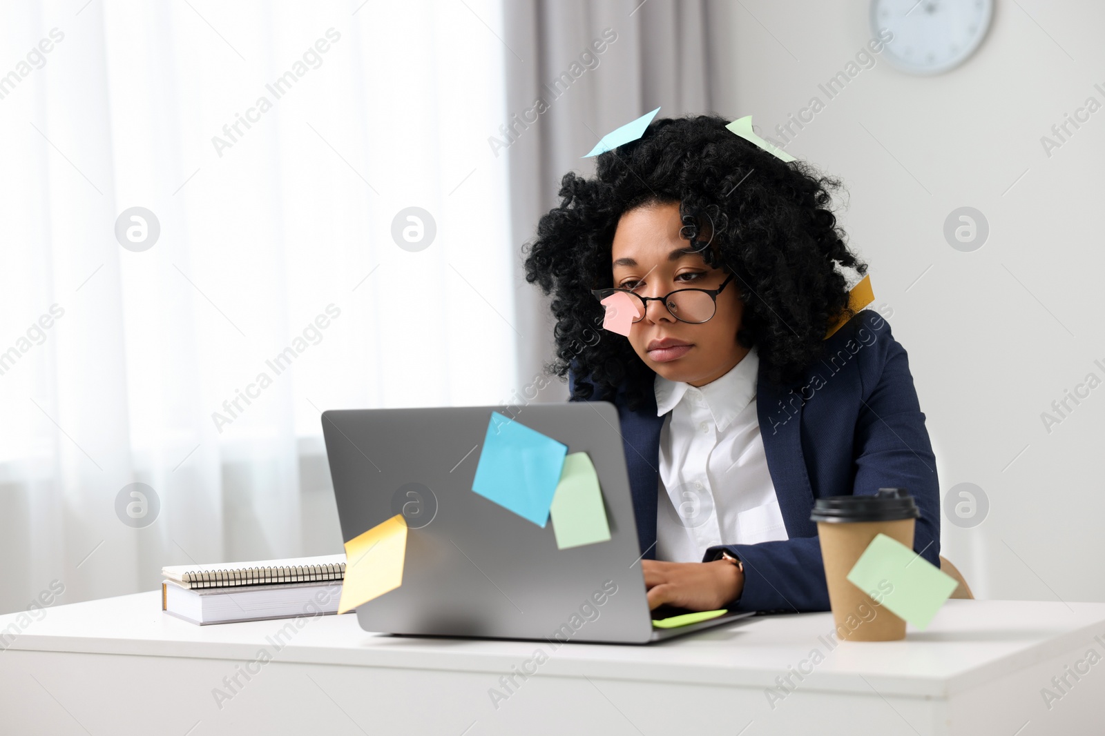 Photo of Deadline concept. Tired woman working with laptop in office, space for text. Many sticky notes everywhere as reminders