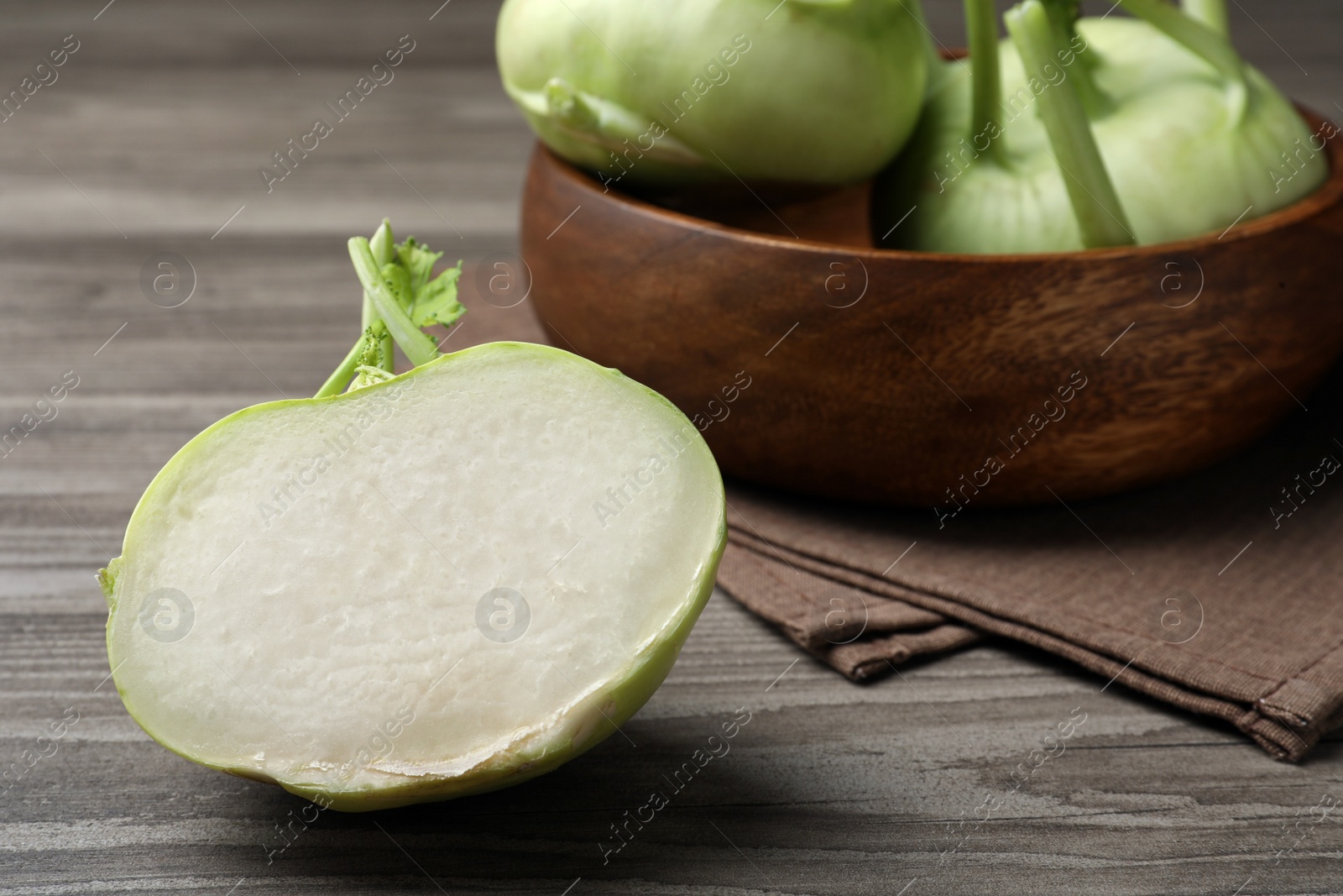 Photo of Whole and cut kohlrabi plants on wooden table