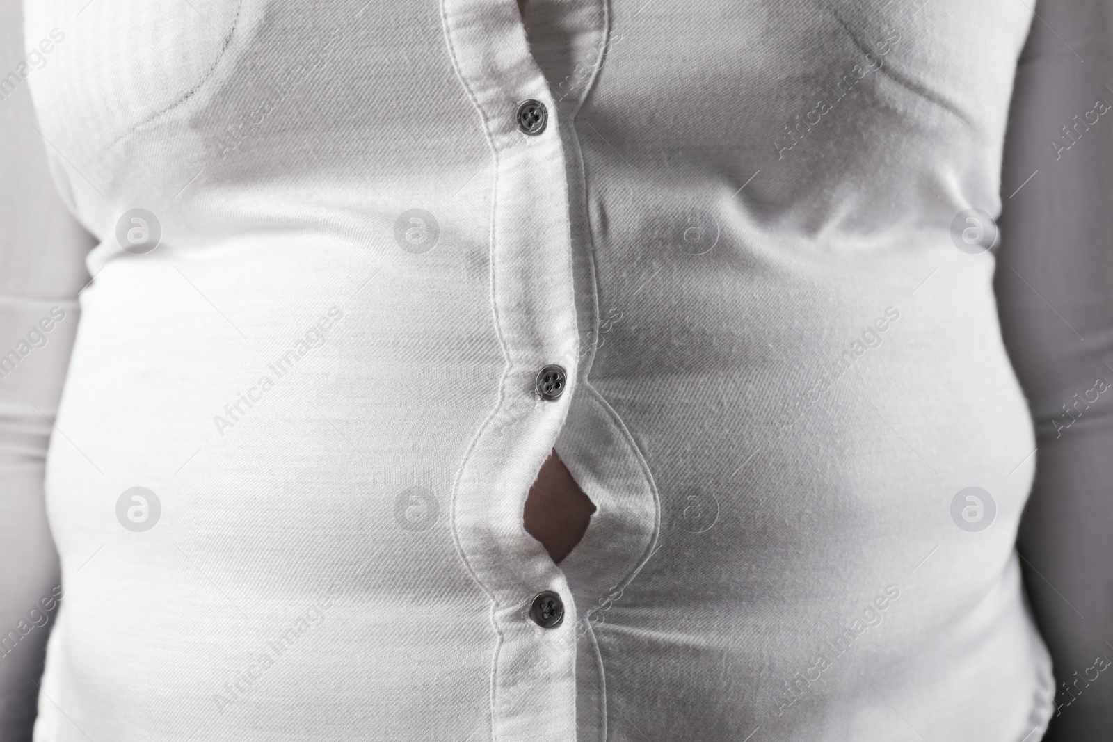 Photo of Overweight woman in tight shirt, closeup. Obesity and weight loss