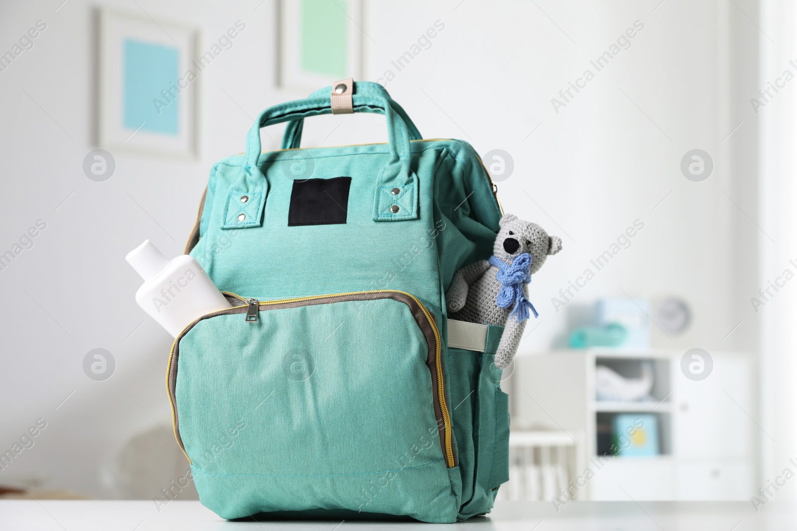 Photo of Maternity backpack with baby accessories on table indoors