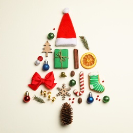 Photo of Flat lay composition with Christmas tree made of different holiday items on light background