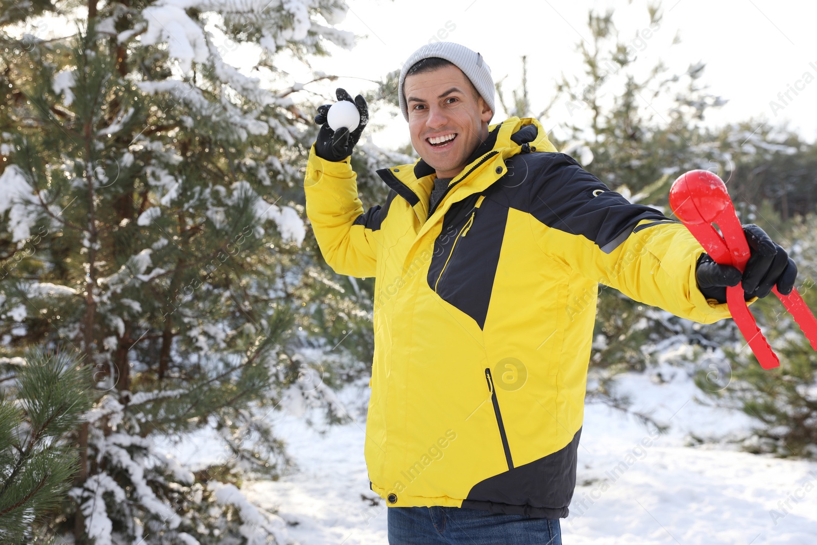 Photo of Happy man with snowball outdoors on winter day. Christmas vacation