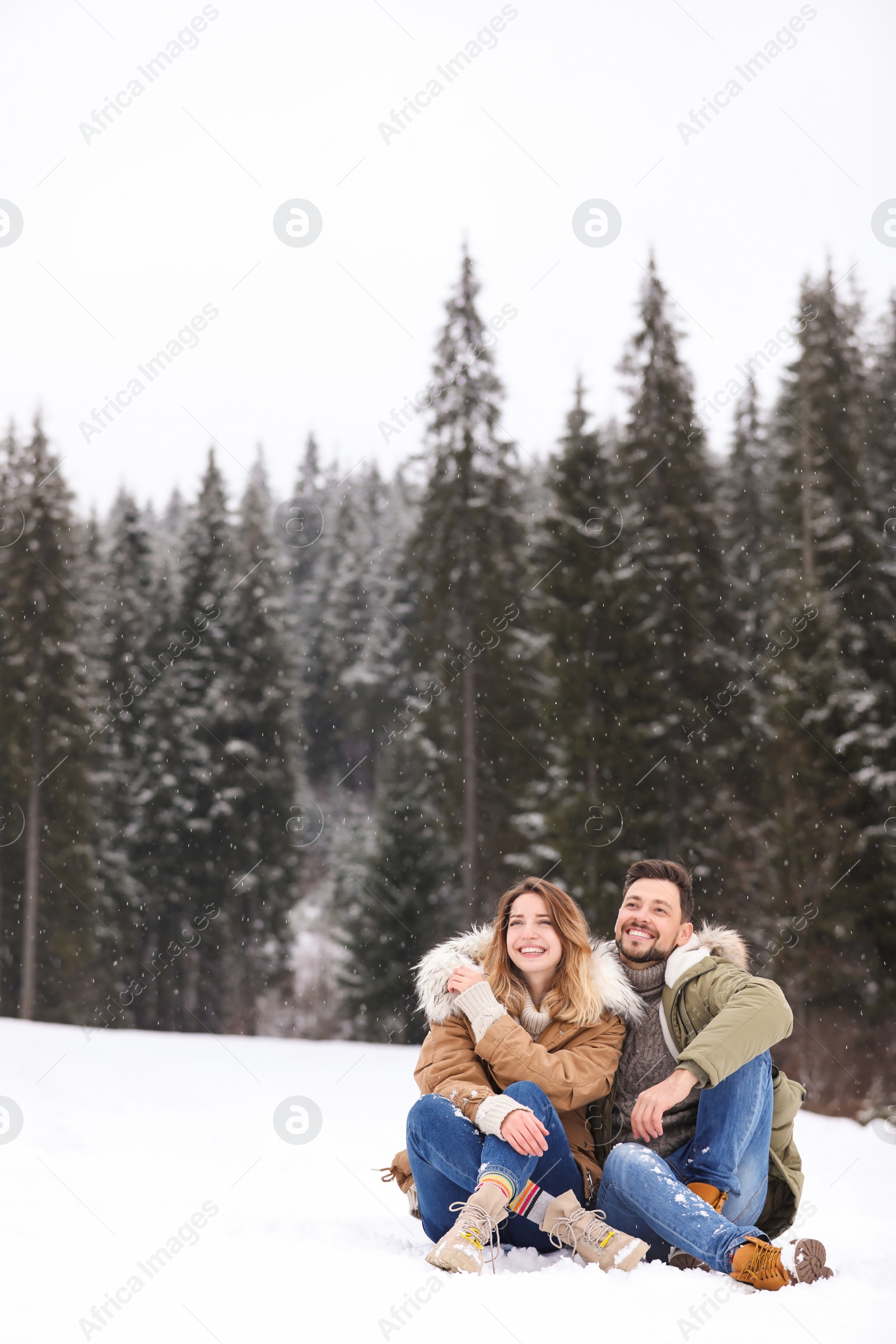 Photo of Couple spending time outdoors on snowy day, space for text. Winter vacation