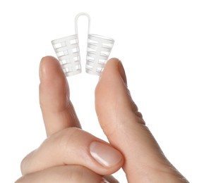 Photo of Woman holding anti-snoring device for nose on white background, closeup
