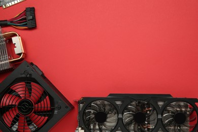 Photo of Graphics card and other computer hardware on red background, flat lay. Space for text