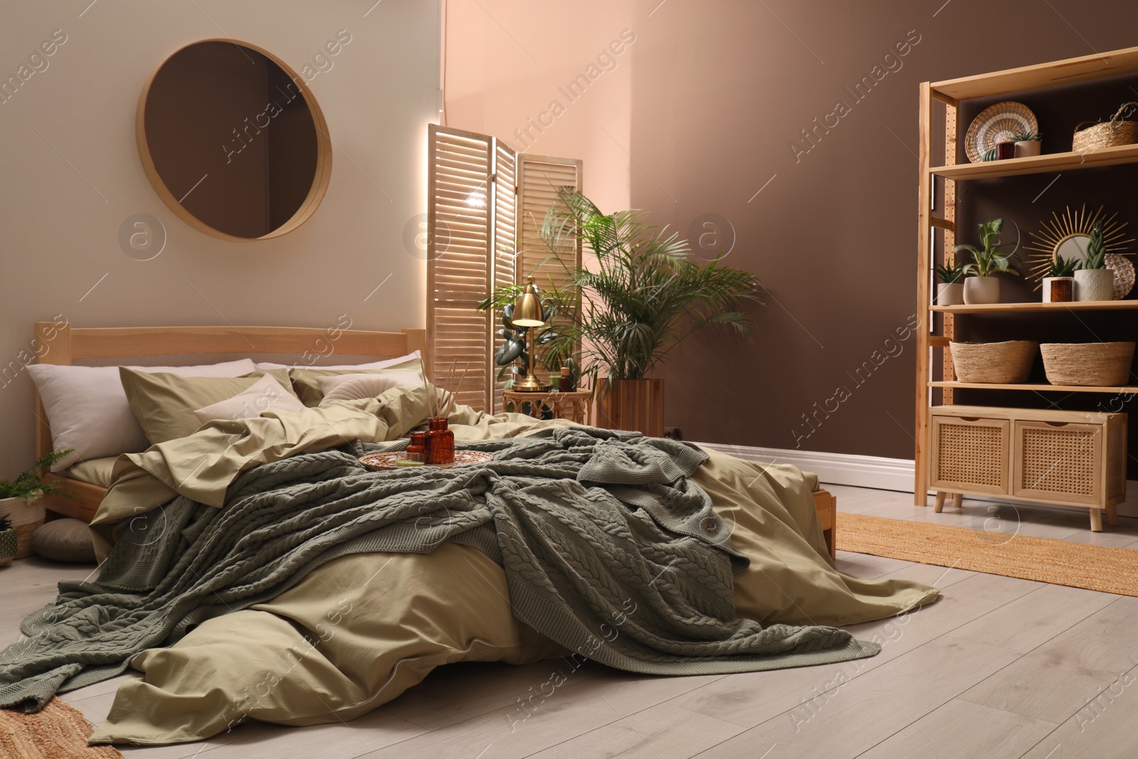 Photo of Stylish interior with large comfortable bed and potted plants