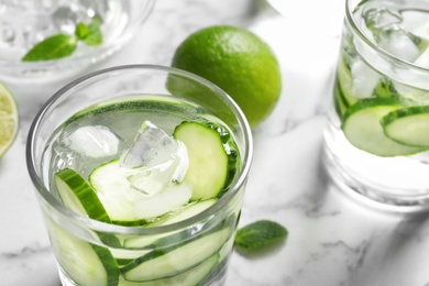 Photo of Glass with fresh cucumber water on table, closeup. Space for text