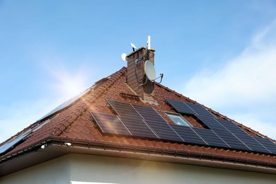 Photo of House with installed solar panels on roof. Alternative energy