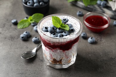 Photo of Delicious chia pudding with blueberries on grey table