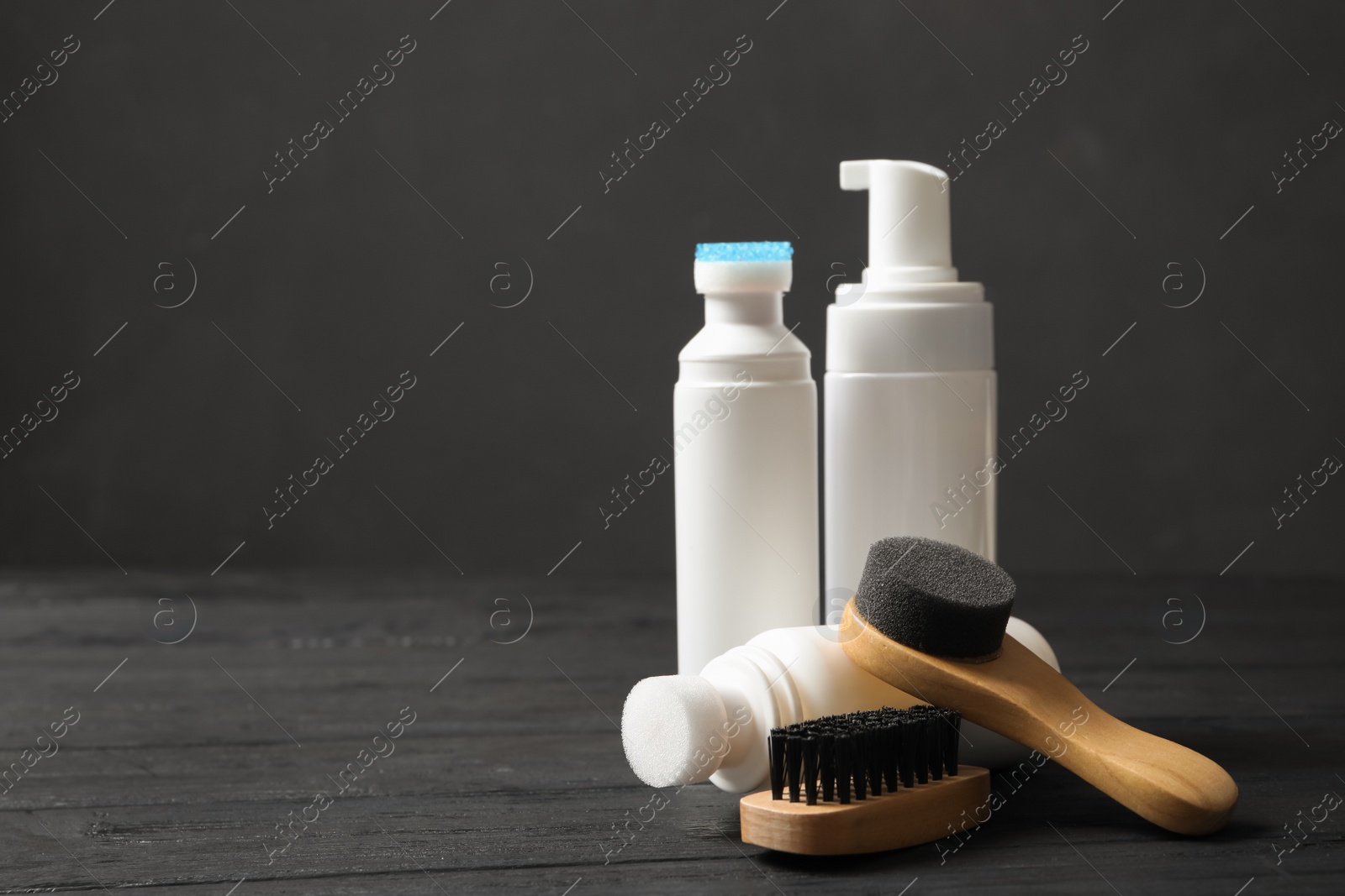 Photo of Composition with shoe care accessories on black wooden table. Space for text