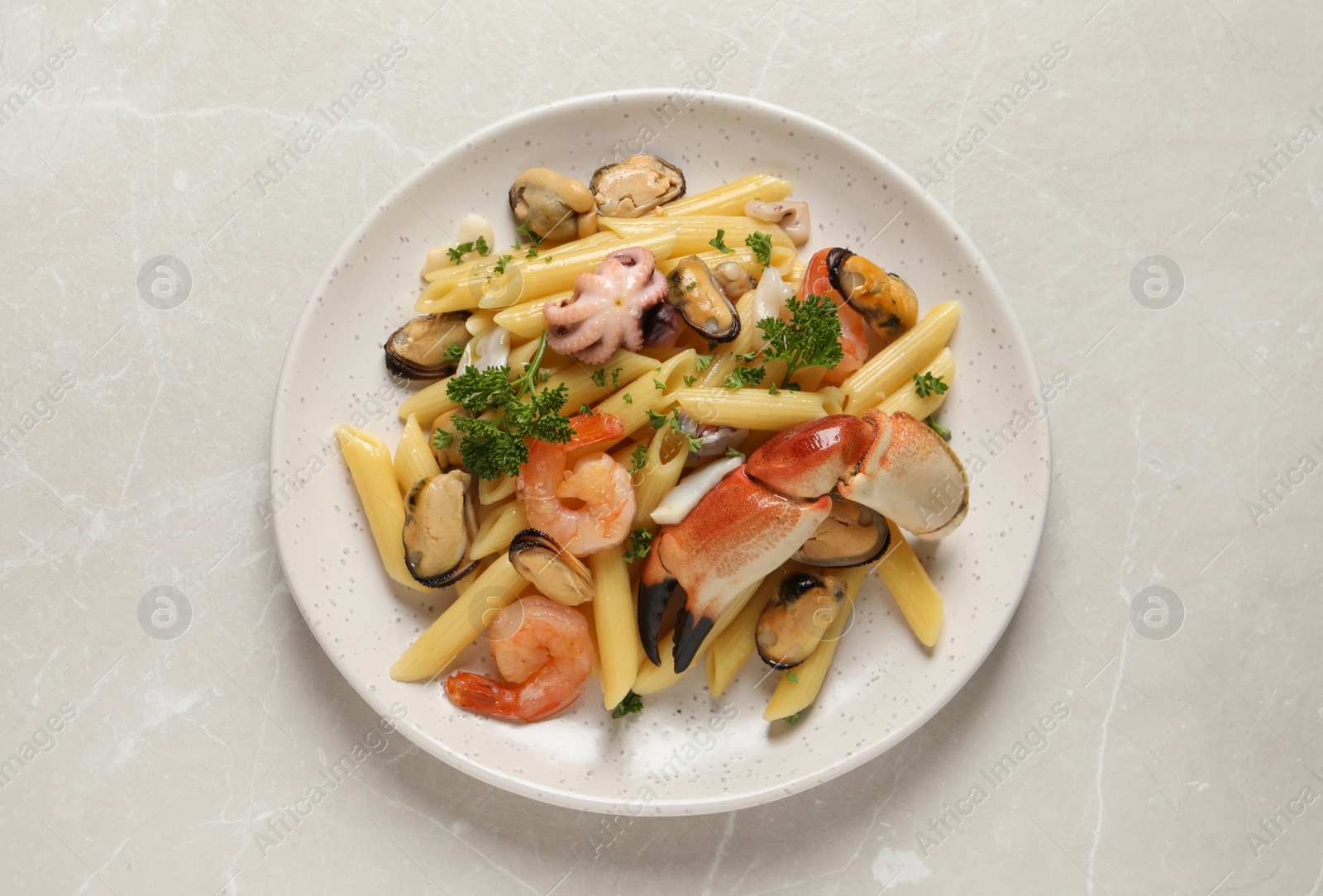 Photo of Delicious pasta with sea food on light grey table, top view