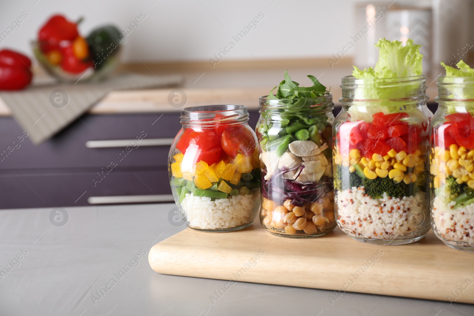 Photo of Glass jars with healthy meal on light grey table