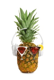 Photo of Funny pineapple with headphones and party glasses on white background