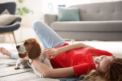 Photo of Young woman with her dog at home