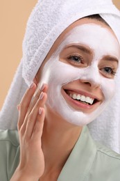 Photo of Woman with face mask on beige background, closeup. Spa treatments