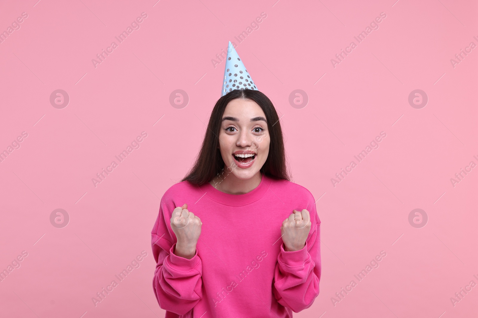 Photo of Happy woman in party hat on pink background