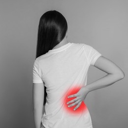 Woman suffering from rheumatism on light background. Black and white effect with red accent in painful area