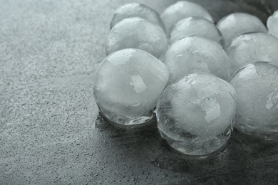 Many frozen ice balls on dark grey table, closeup. Space for text
