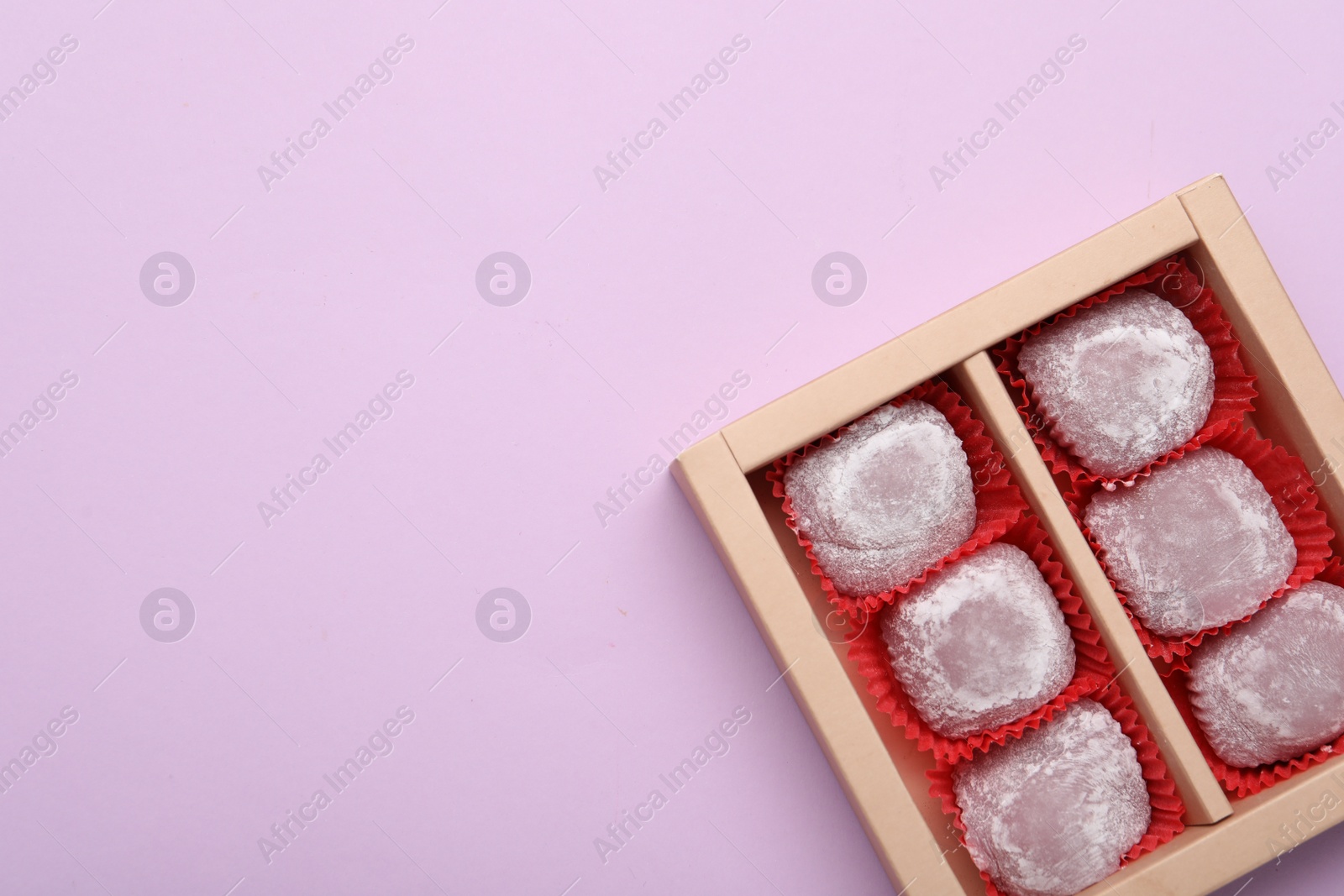Photo of Box of delicious mochi on light background, top view with space for text. Traditional Japanese dessert