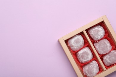 Box of delicious mochi on light background, top view with space for text. Traditional Japanese dessert