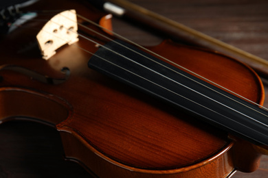 Photo of Classic wooden violin on table, closeup view