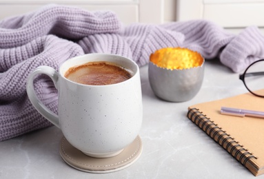 Composition with cup of hot chocolate and notebook on windowsill. Winter drink