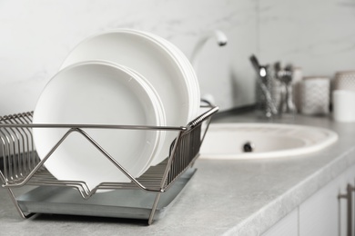 Photo of Drying rack with clean dishes on kitchen counter. Space for text